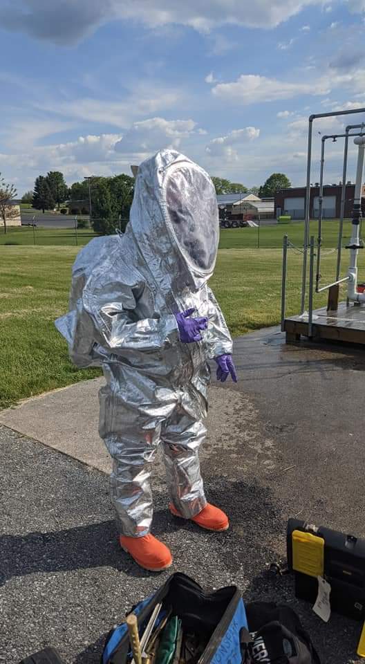 Responder in practice Level A PPE suit practicing at Base HazMat Leak Tree Training Prop.